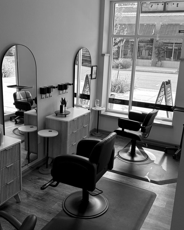 Styling stations at Identity Salon & Spa, with the arched mirrors and the window onto Main Street