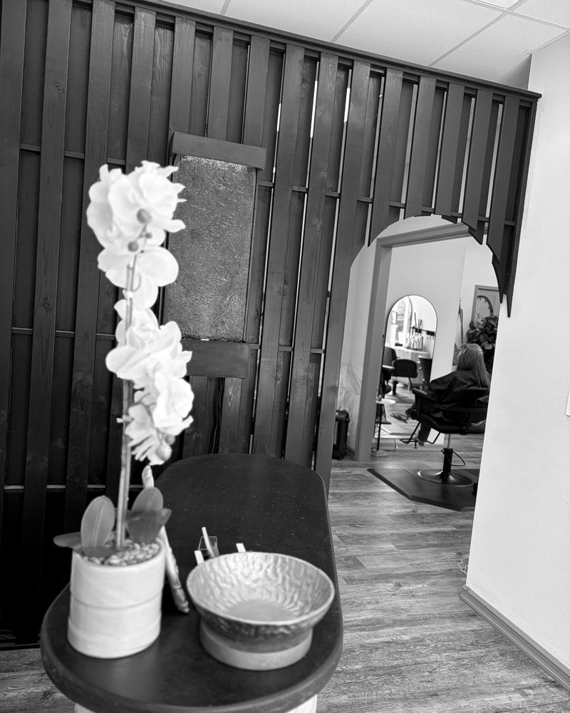 An orchid on the front table beside the slat wall at Identity Salon & Spa